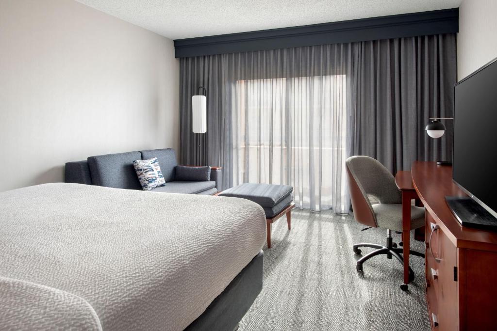 沃灵福德Courtyard by Marriott New Haven Wallingford的一间配有床、书桌和椅子的酒店房间