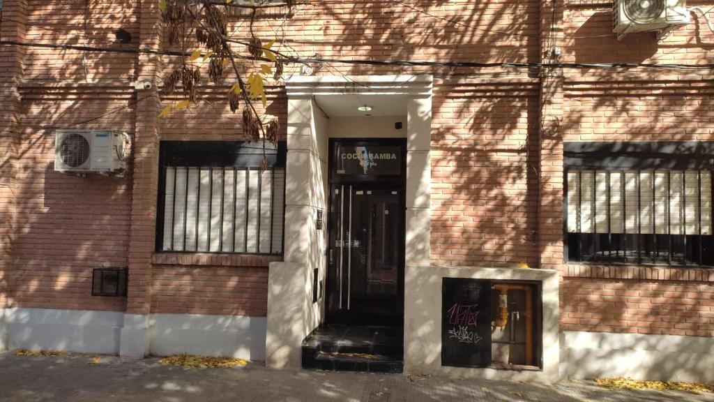 un edificio de ladrillo con una puerta y ventanas negras en Departamento 2 Habitaciones en Rosario