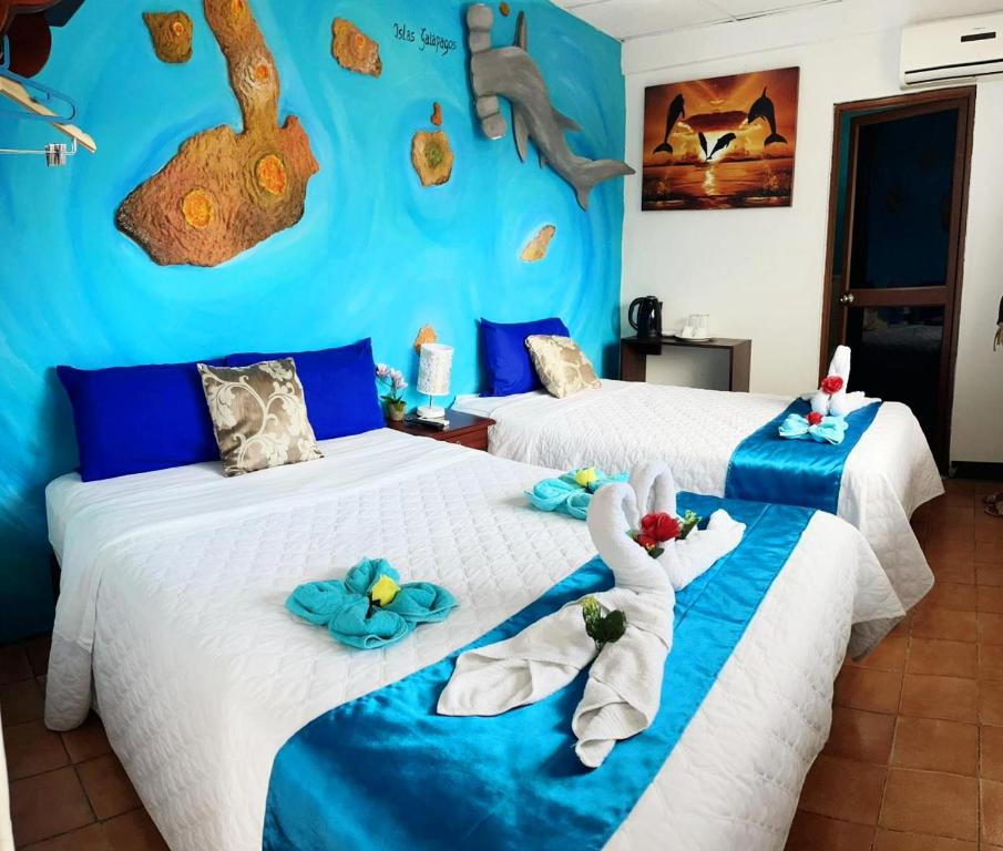 2 Betten in einem Zimmer mit Handtüchern darauf in der Unterkunft Puerto Ayora Island in Puerto Ayora
