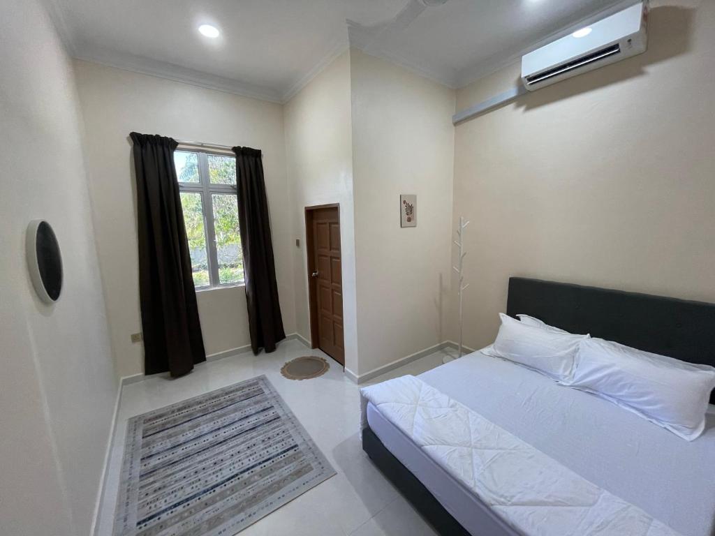 a bedroom with a white bed and a window at King's Cottage Homestay Kubang Kerian in Kota Bharu