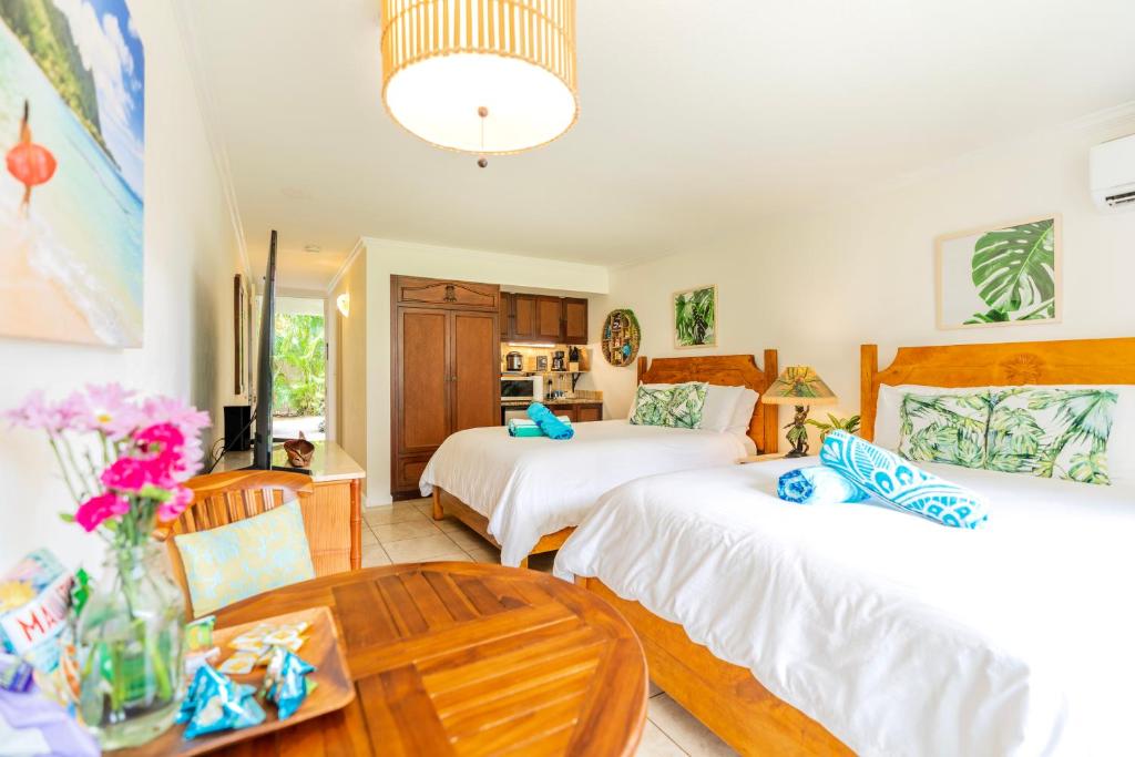a bedroom with two beds and a table at Islander Ocean Resort Condo # 166 in Kapaa