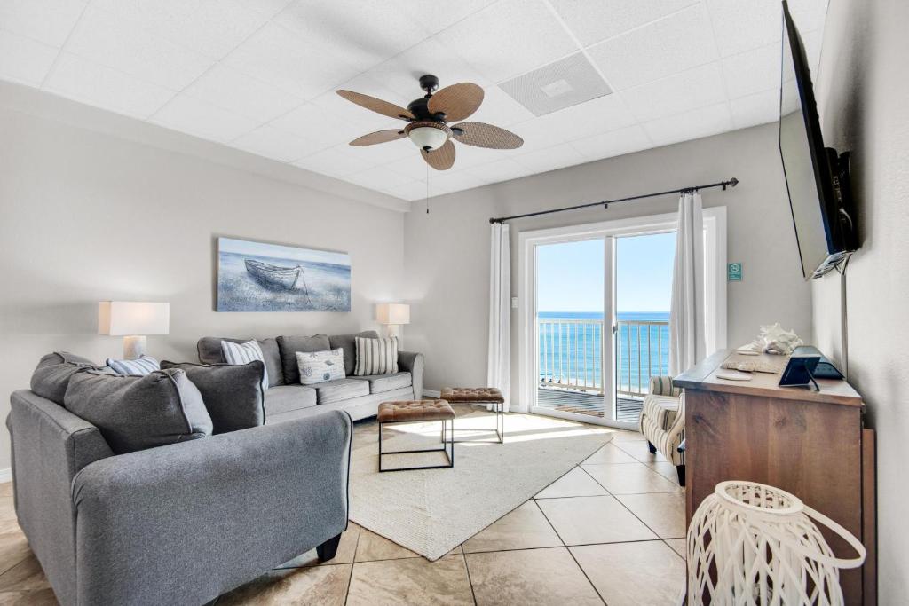 - un salon avec un canapé et un ventilateur de plafond dans l'établissement Sans Souci unit 209, à Pensacola Beach