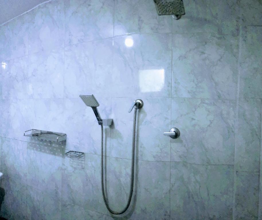 a shower with a hose in a bathroom at Kalimetiya Beach Cabana in Hungama