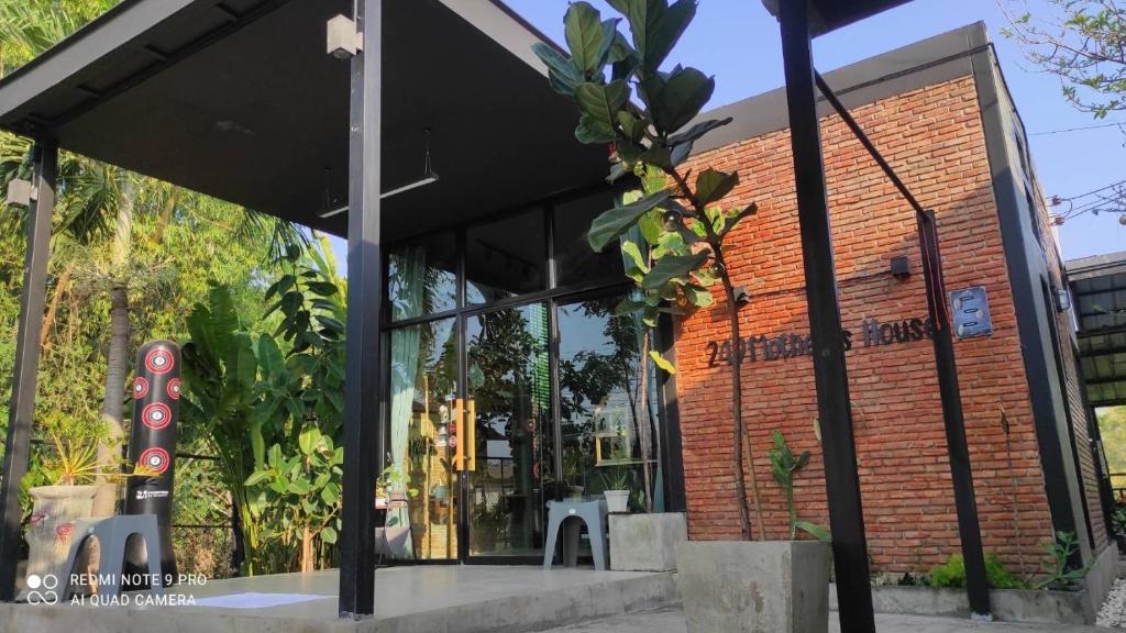 un edificio de ladrillo rojo con una gran ventana en Mother’s House(บ้านแม่) en Wang Saphung