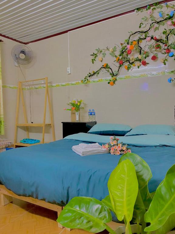 a bedroom with a bed with a tree painted on the wall at Rose's House in Khu Chi Lăng