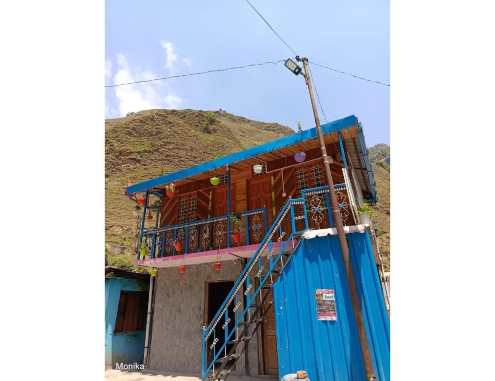 a blue building with a balcony on a hill at Sandeep Home stay, Chakrata in Chakrāta