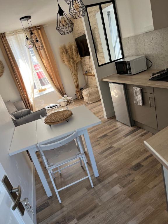 małą kuchnię z białym stołem i stołkiem w obiekcie Appartement Centre-ville w mieście Crépy-en-Valois