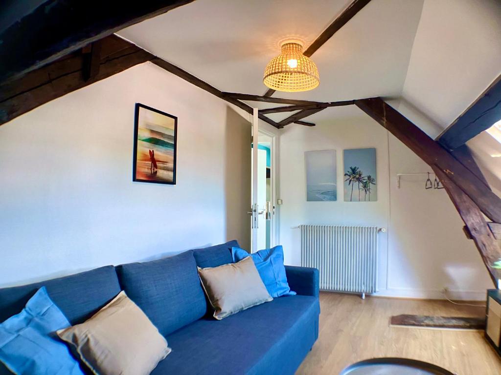 a blue couch in a living room with a ceiling at F3 La Plage - Gare - Netflix - Wifi - Parking in Évreux