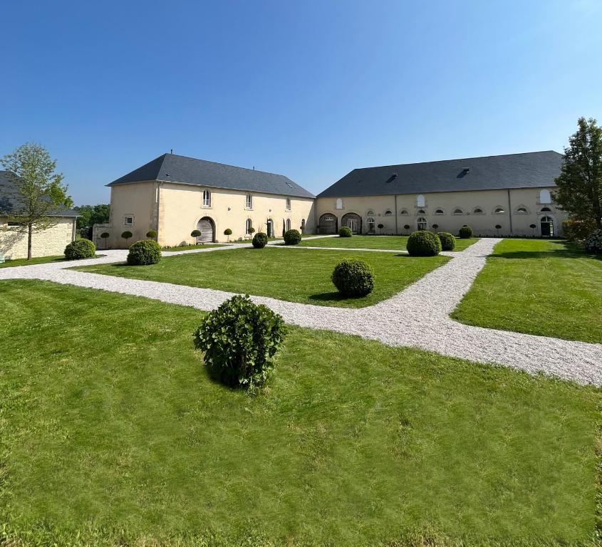 un grand bâtiment avec une passerelle dans l'herbe dans l'établissement DOMAINE DU GRAND CAUGY, à Saint-Vigor-le-Grand