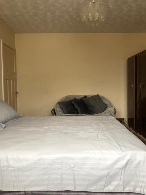 a bedroom with a white bed with a chandelier at Budget London Room in London