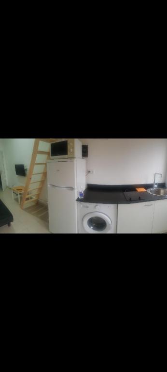 a kitchen with a sink and a washing machine at Charmant studio in La Verrière