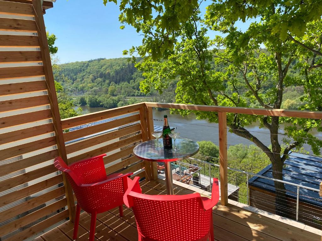 einen Tisch und Stühle auf einer Terrasse mit Aussicht in der Unterkunft Apartmán - E - Vyhlídka nad řekou in Zdiby