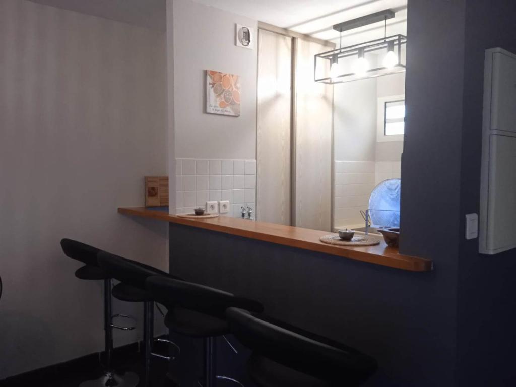 ein Bad mit einem Waschbecken und einem Spiegel in der Unterkunft Les clés du sud sauvage in Saint-Joseph
