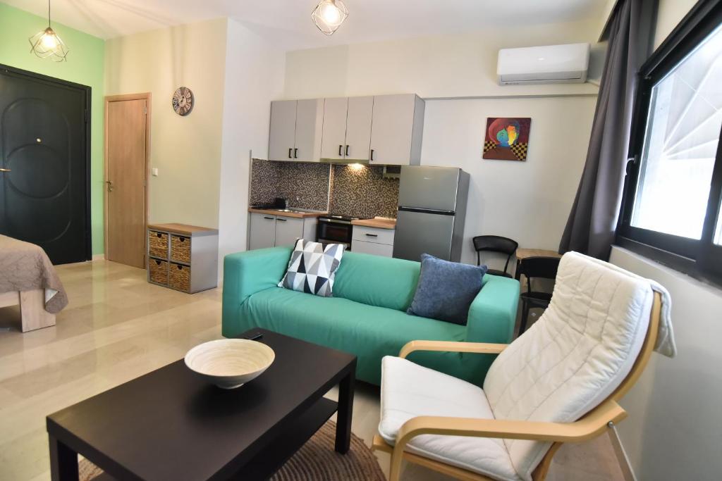a living room with a green couch and chairs at No15 central apartment in Kavala