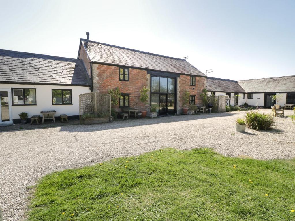 a group of buildings with a gravel driveway at The Barn in Shaftesbury