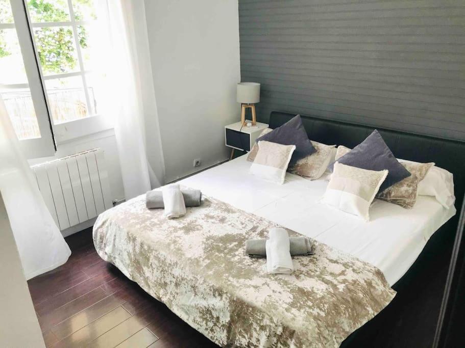 een slaapkamer met een groot bed met witte lakens en kussens bij Villa Wanderlust Sitges Hills. Exclusive pool. in Olivella