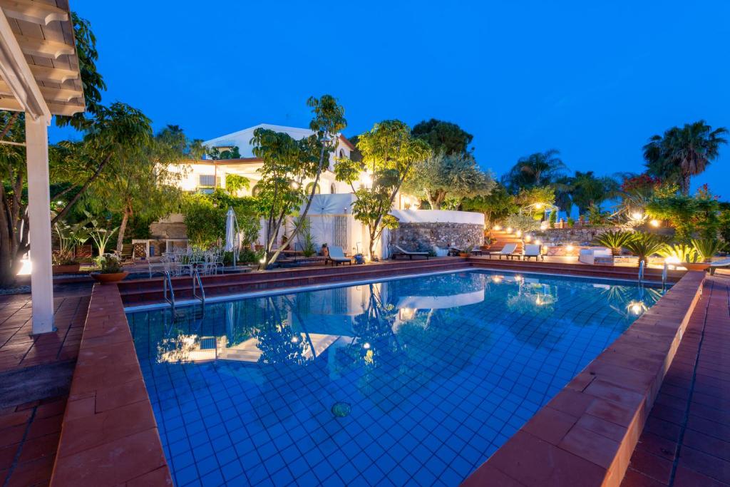 una piscina en un complejo por la noche en Villa with pool & jacuzzi, en Taormina