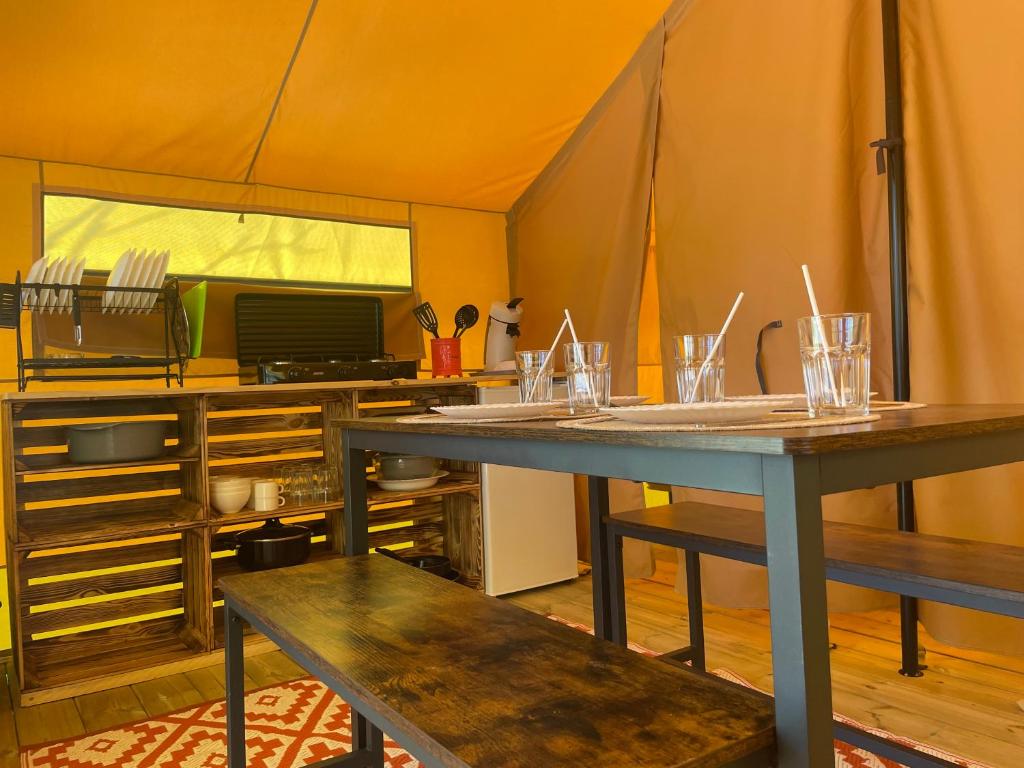 Chauzon的住宿－Camping Beaussement Samouraï，客房内的帐篷配有桌子和长凳