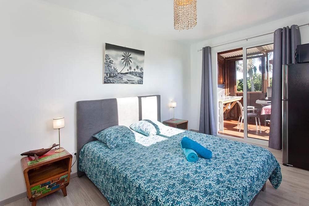 - une chambre dotée d'un lit avec un objet bleu dans l'établissement L’escapade créole jacuzzi privatif Bungalow Ananas, à Saint-Joseph