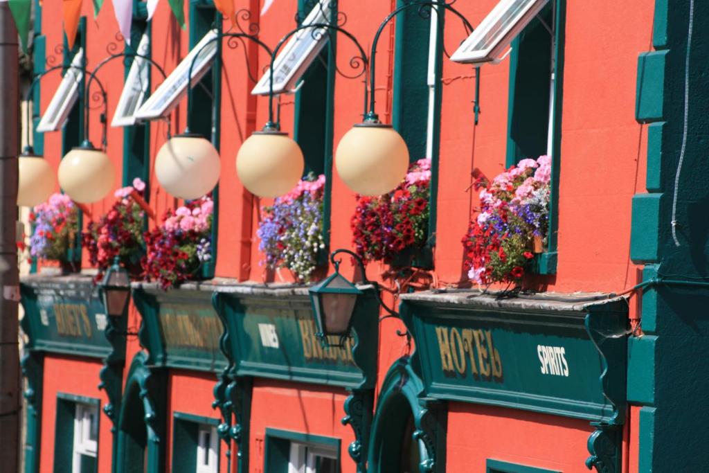 eine Reihe von Gebäuden mit Blumenkästen und Lichtern in der Unterkunft Bridge Hotel in Arklow