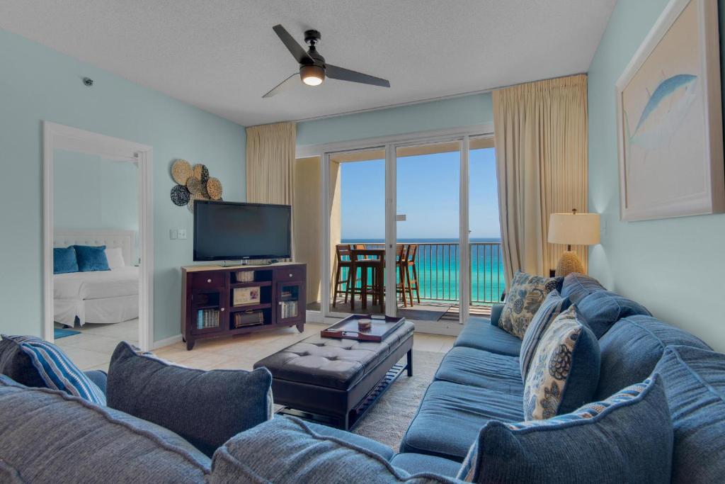 a living room with a blue couch and a television at Leeward Key 903 in Destin