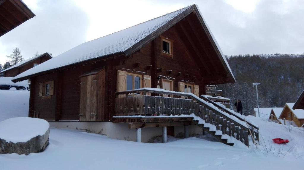 a log cabin with a snow covered porch and stairs at Chalet Résivacances n°32 - La Joue du Loup in Le Dévoluy