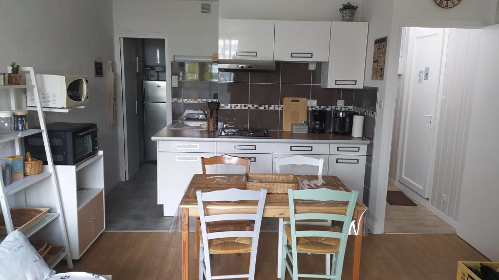 une cuisine avec une table et des chaises dans l'établissement Les Becs - Appartement bord de mer, 1 chambre, à Saint-Hilaire-de-Riez