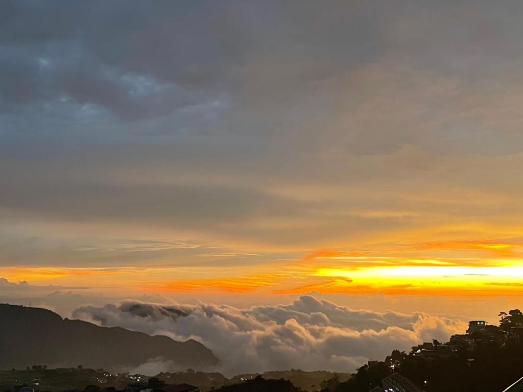 a view of the sunset from above the clouds at Mountain and Sunsetview Baguio Residences in Baguio