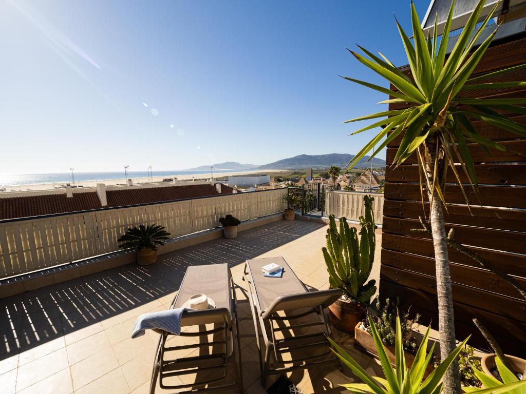 a table and chairs on a balcony with the beach at Lankarifa Apartment in Tarifa
