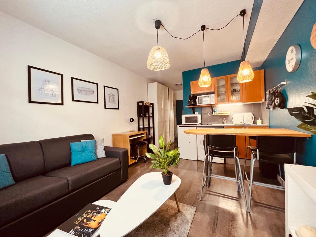 a living room with a couch and a table at Le Jean-Jaurès / Joli studio in Nîmes