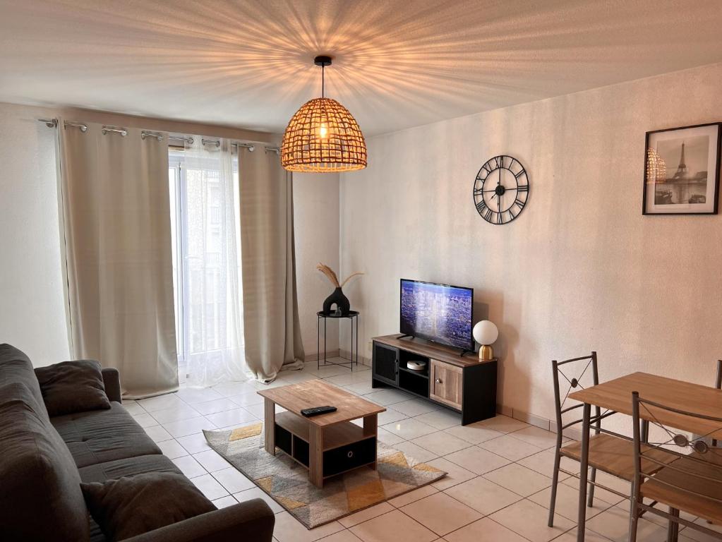 sala de estar con sofá y TV en Apparthotel - Horizon Poitevin en Poitiers