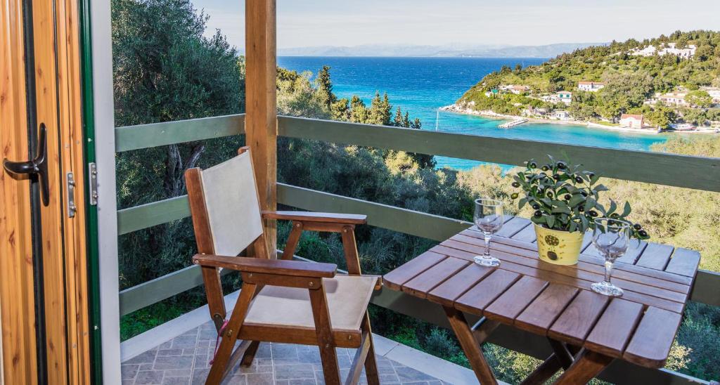 a table and chairs on a balcony with a view of the ocean at Villa Jezz in Lákka