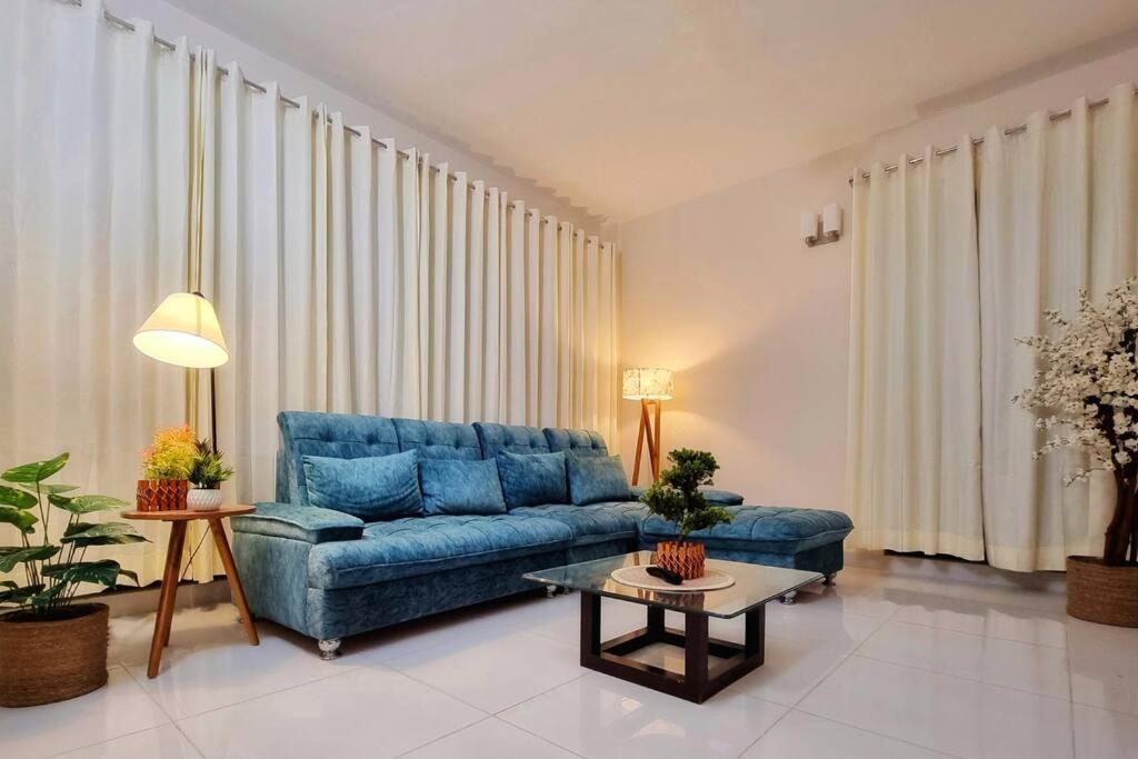 達卡的住宿－Dianella Inn，客厅配有蓝色的沙发和桌子