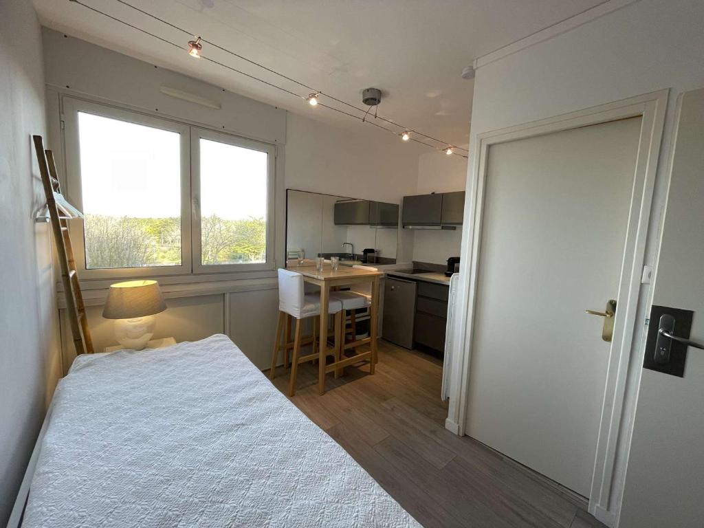 une petite chambre avec un lit et une cuisine dans l'établissement Studio rénové 2 pers avec parking, wifi, proche plage - FR-1-224C-28, à Saint-Jean-de-Monts