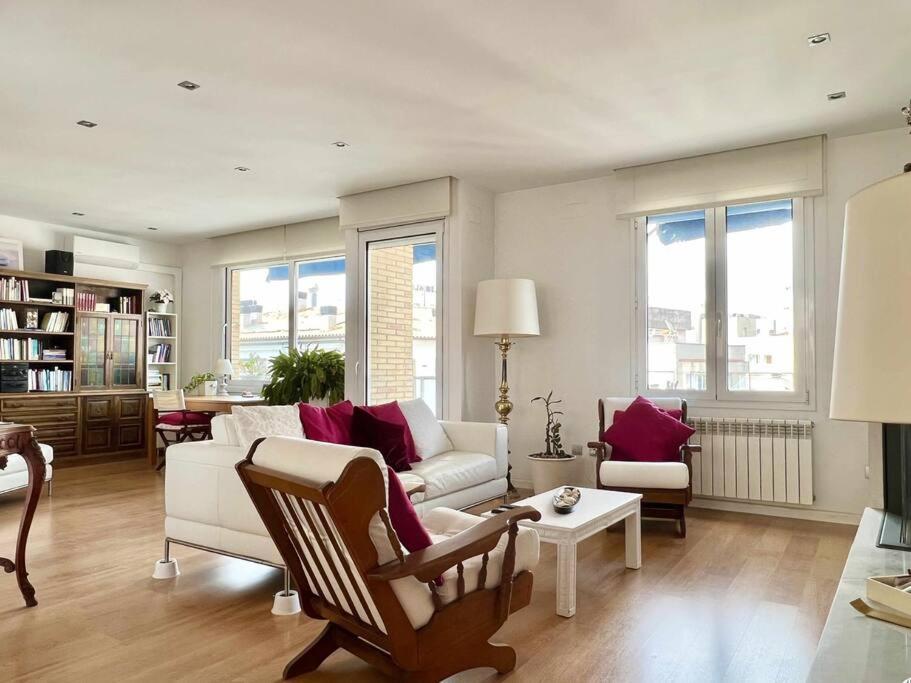 ein Wohnzimmer mit einem Sofa und einem Stuhl in der Unterkunft Moderno y amplio apartamento en el centro de Roses in Roses