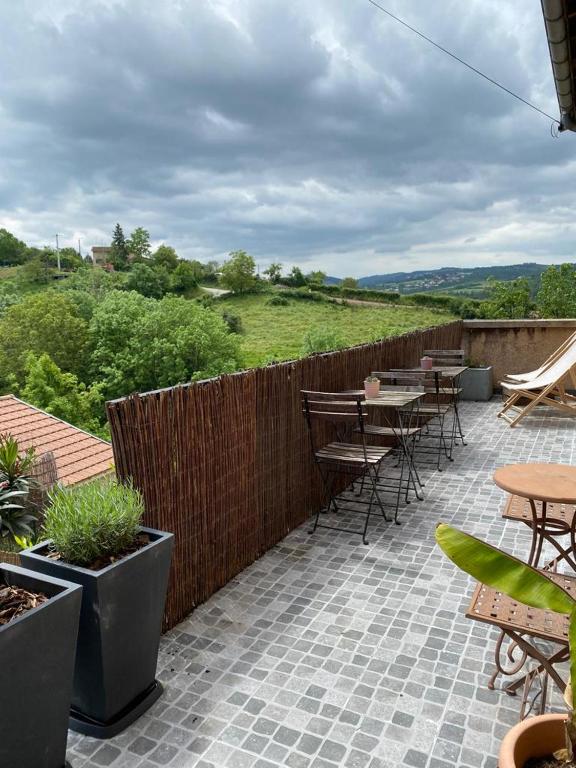 d'une terrasse avec des tables et des chaises et une clôture. dans l'établissement Maison sur cour, à Courzieu