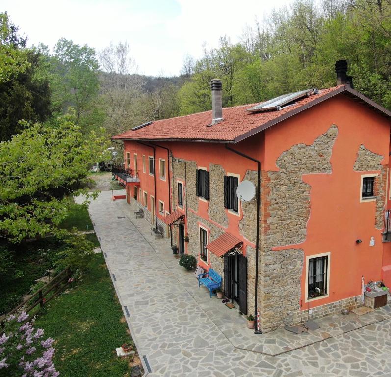 pomarańczowy budynek z ścieżką przed nim w obiekcie B&B Cascina Grattinera w mieście Sale San Giovanni