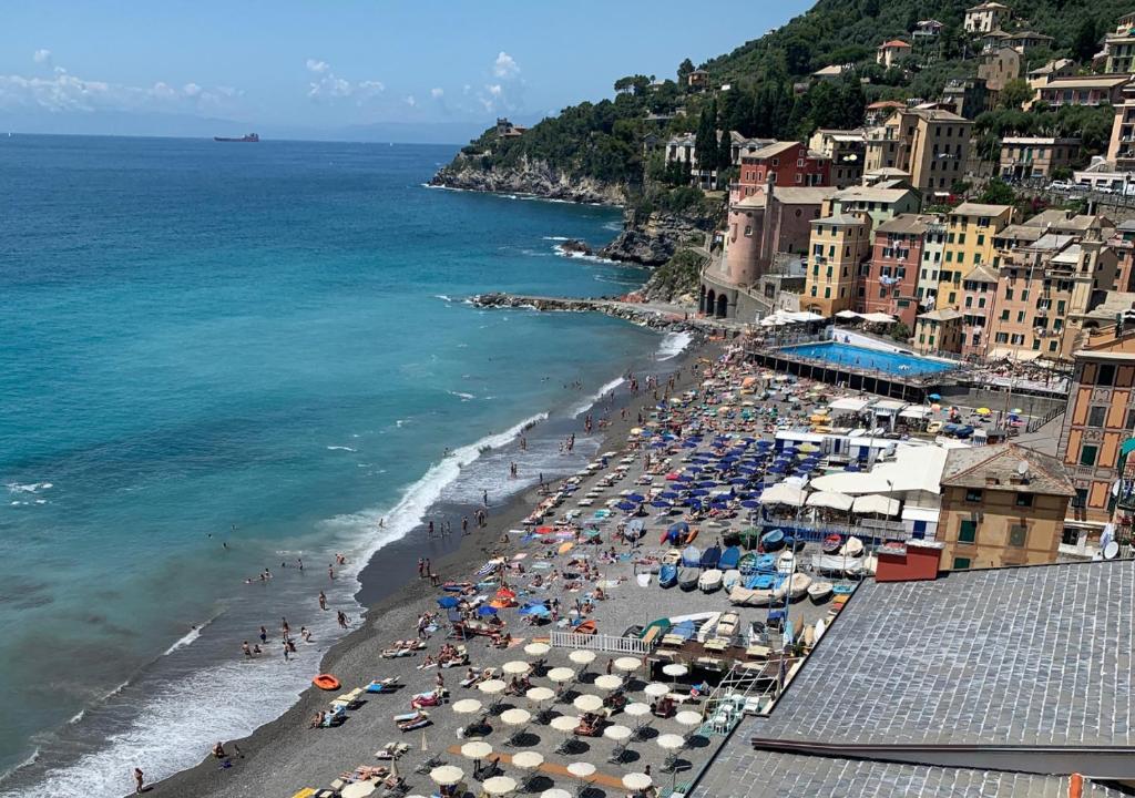 a beach with umbrellas and people on the beach at Appartamento a 250mt dal mare con parcheggio sotto casa in Sori