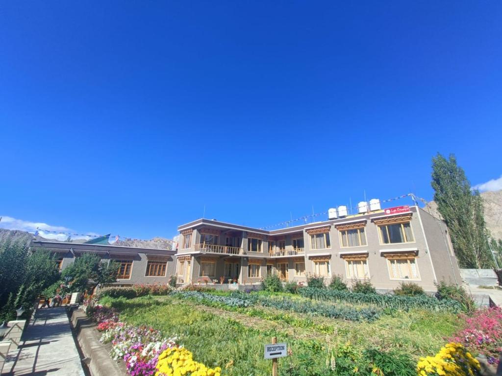 a large building with a garden in front of it at Leh Stumpa in Leh