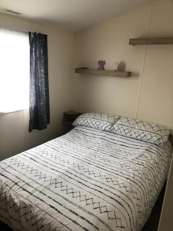 1 dormitorio con cama blanca y ventana en Lunas chill pad, en Edimburgo
