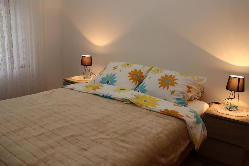 a bedroom with a bed with two lamps on tables at Apartman Lagodi in Križevci