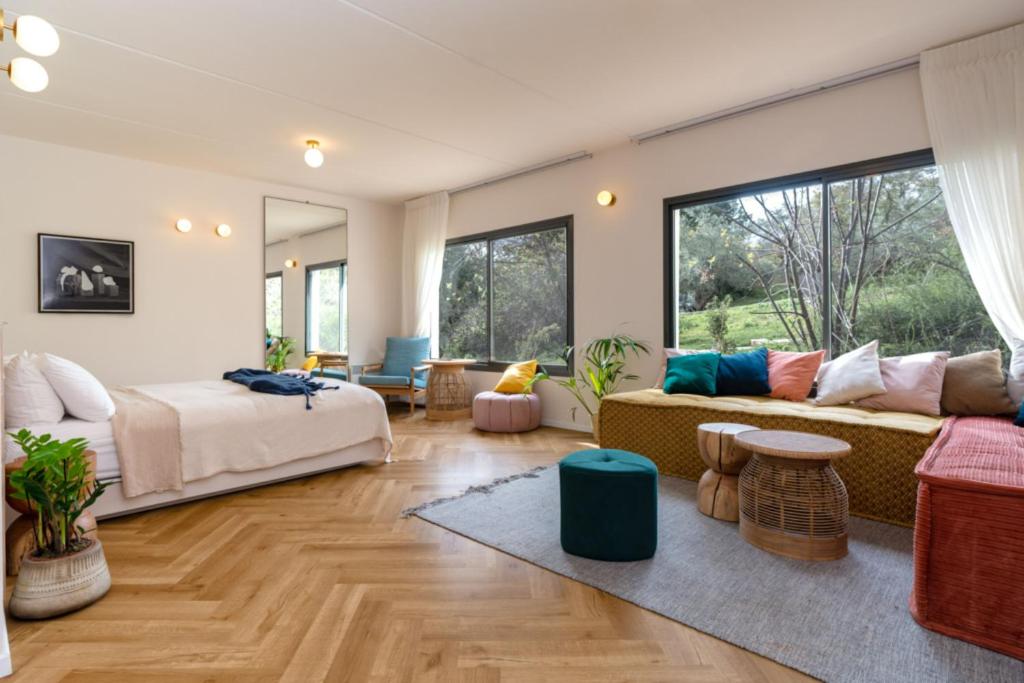 - un salon avec un lit et un canapé dans l'établissement Slowness - Kibbutz Moran, à Moran
