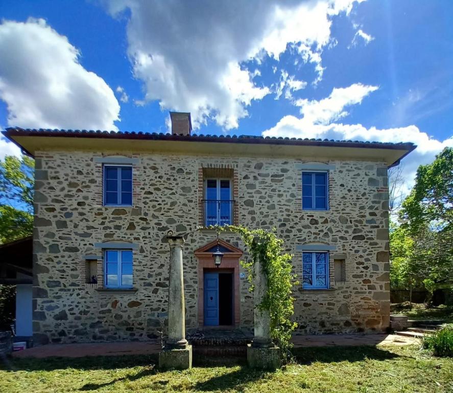 une ancienne maison en pierre avec une porte bleue dans l'établissement A Casa là - l'Aiola, à Paciano