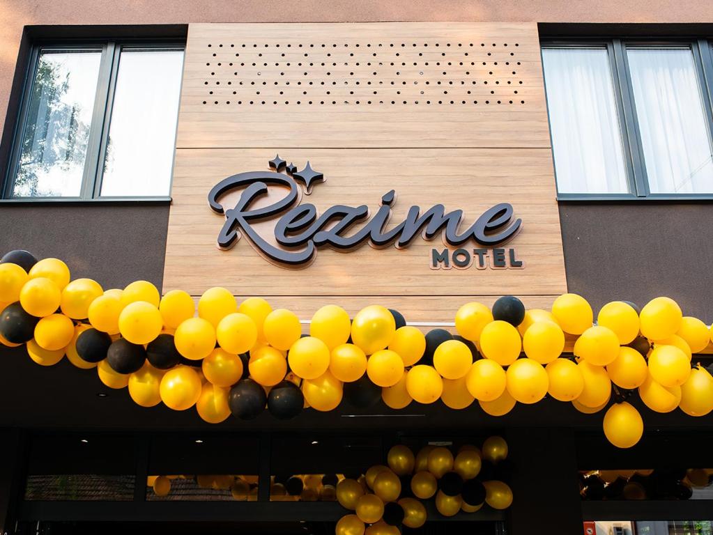 una señal para un restaurante con globos amarillos y negros en Hotel Rezime, en Zenica