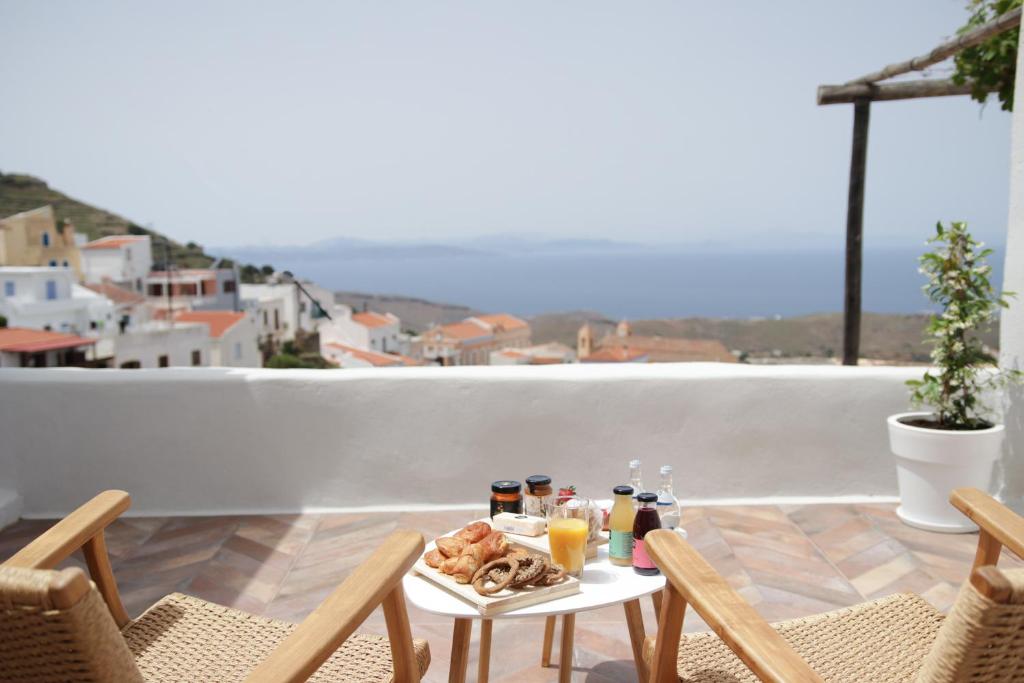 a table with food and drinks on a balcony at VILLA CALLIOPE KEA in Ioulida