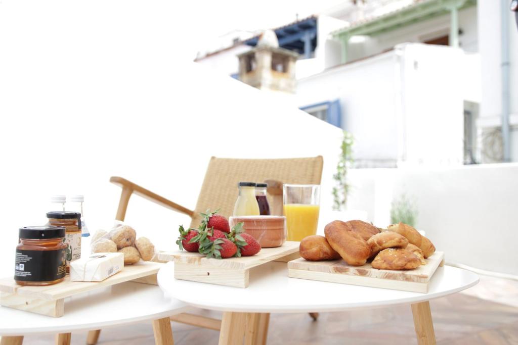 una mesa con dos bandejas de pan y zumo de naranja en VILLA CALLIOPE KEA, en Ioulida