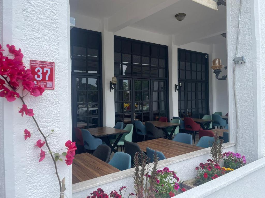 een restaurant met tafels en stoelen in een gebouw bij Blue Topas Otel in Burhaniye