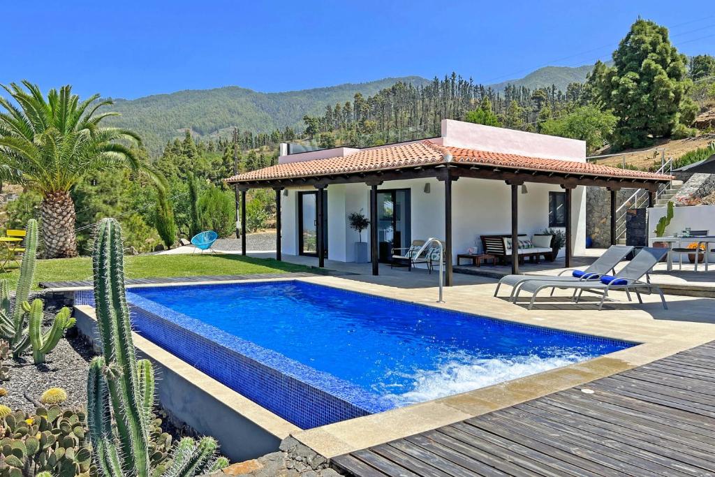 a villa with a swimming pool and a house at Casa El Consuelo in Tijarafe