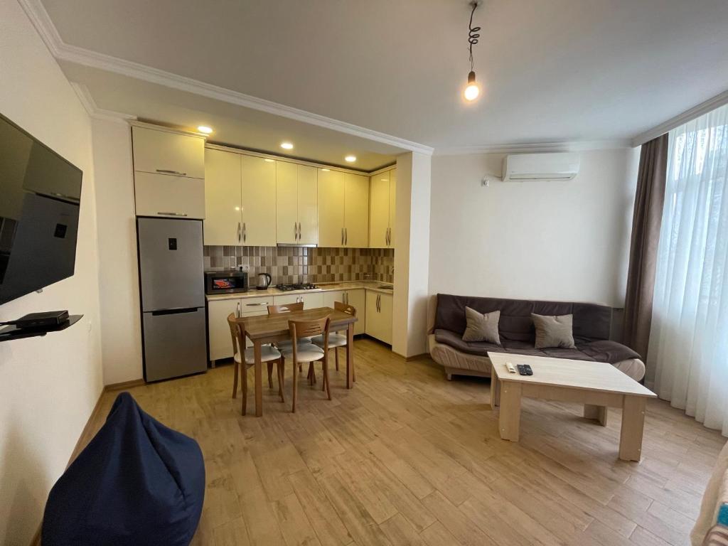 kuchnia i salon ze stołem i kanapą w obiekcie Apartment on Melikishvili 51 w mieście Batumi