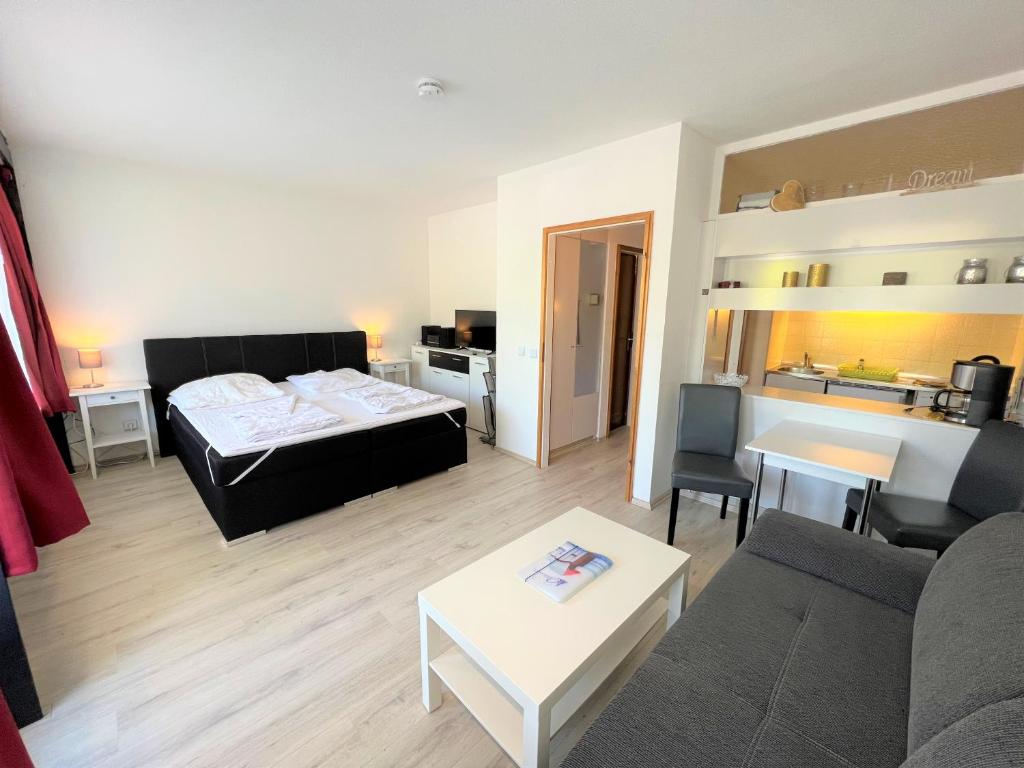 ein Wohnzimmer mit einem Sofa und einem Bett in der Unterkunft Ferienpark Sierksdorf App 580 - Strandlage in Sierksdorf